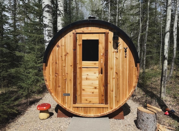 A wooden cabin with a door, a small window, and a mushroom decoration.