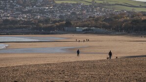 A beach with a town in the background. - Beach House (Colwyn Bay)