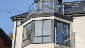 A corner bay window with a balcony, a metal railing, and a clear sky. - Beach House (Colwyn Bay)