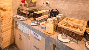 Una cocina con armarios de madera, encimera de mármol y una lámpara colgante.