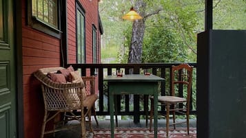 Relax on the charming porch with a wooden table and two comfortable chairs.