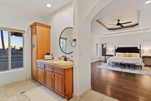 A modern bedroom with a large bed, a ceiling fan, and a view of the outdoors through a window. - UPSCALE Arrowhead Retreat + Heated Pool & Golf Course Views! (Glendale)