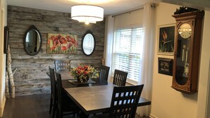 A dining area with a wooden wall, a chandelier, and a clock. - one level brick home with pet friendly fenced back yard , close to Chattanooga  (Ooltewah)