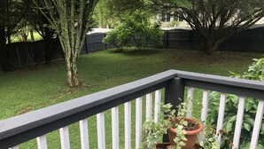 A wooden deck with a white railing and a potted plant on a crate labeled "KIRSTLEIN". - one level brick home with pet friendly fenced back yard , close to Chattanooga  (Ooltewah)