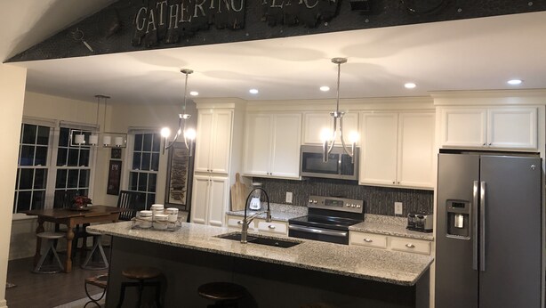 A modern kitchen with white cabinets, stainless steel appliances, and a granite countertop. - one level brick home with pet friendly fenced back yard , close to Chattanooga  (Ooltewah)