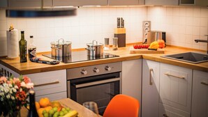 Une cuisine moderne avec des meubles blancs, un plan de travail en bois et des appareils électroménagers en acier inoxydable.