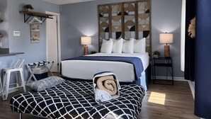 Ein Schlafzimmer mit einem Bett, Nachttischen, einem Deckenventilator und einem dekorativen Kopfteil.