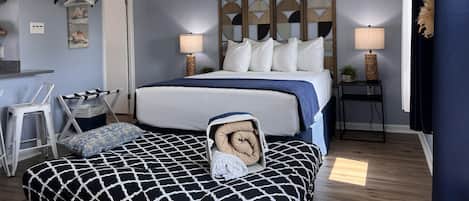 Quarto com cama, mesas de cabeceira, ventilador de teto e cabeceira decorativa.