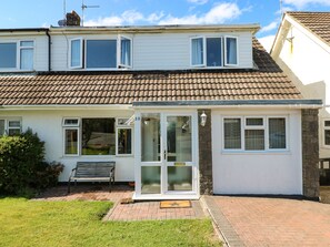 A two-story house with a tiled roof, a front porch, and a bench. - 53 St. Brides View (Haverfordwest)