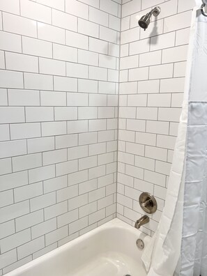 Ducha y bañera combinadas, toallas, jabón y papel higiénico