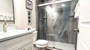 Ein Badezimmer mit Toilette, Waschbecken und Duschbereich.