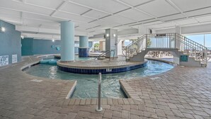 Una piscina interior de diseño circular, con una estación de salvavidas y una escalera que lleva a un nivel superior.