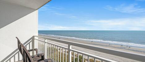 Een balkon met uitzicht op het strand en de oceaan.