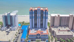 Un hotel con un edificio central de techo rojo, rodeado de otras construcciones.