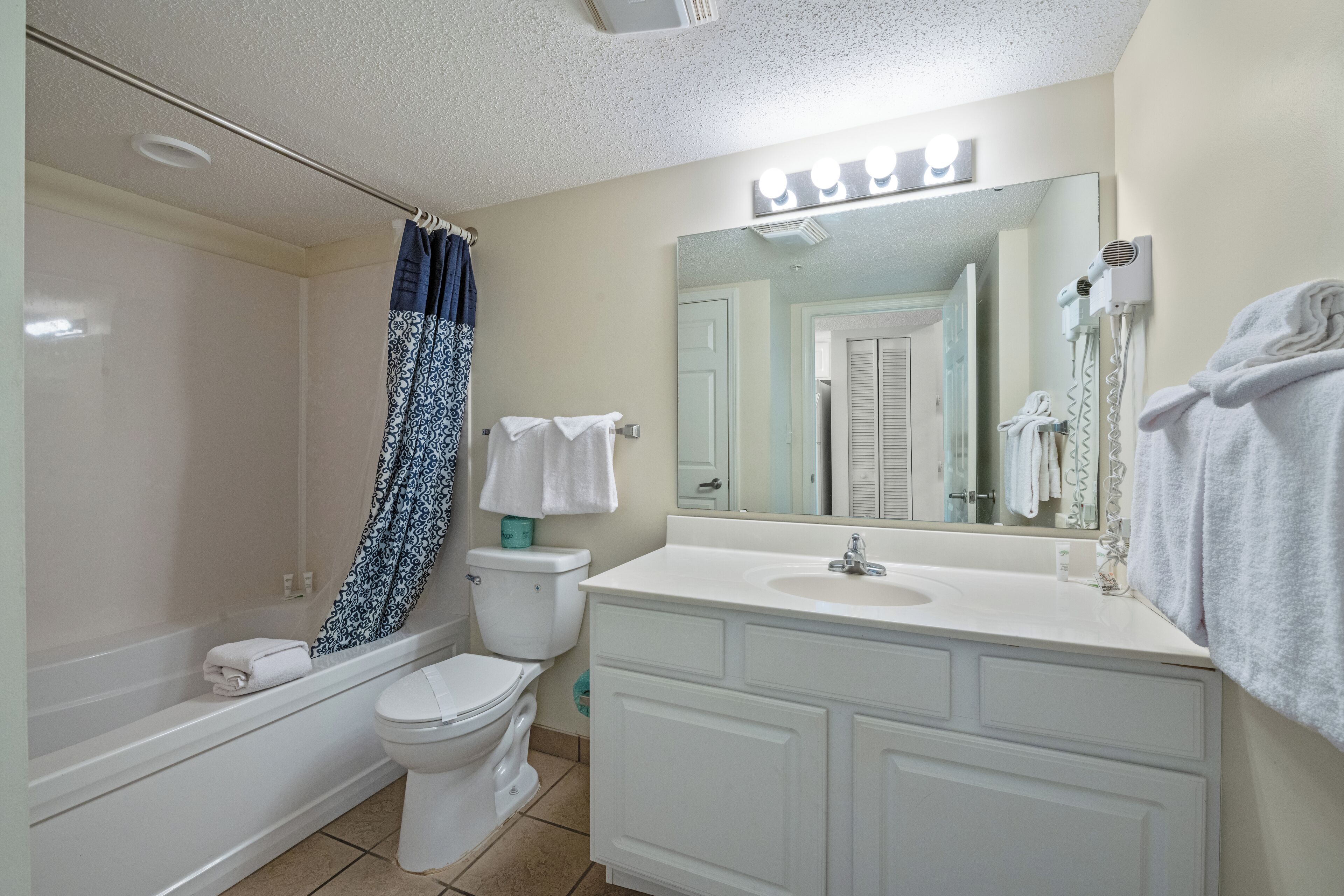 A bathroom with a bathtub, toilet, and sink.