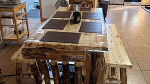 Ein Essbereich mit Holztisch und Stühlen, einer Waschmaschine und einer Küche im Hintergrund.