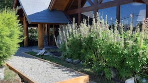 A wooden cabin with a sloped roof and a gravel pathway leading to the entrance.