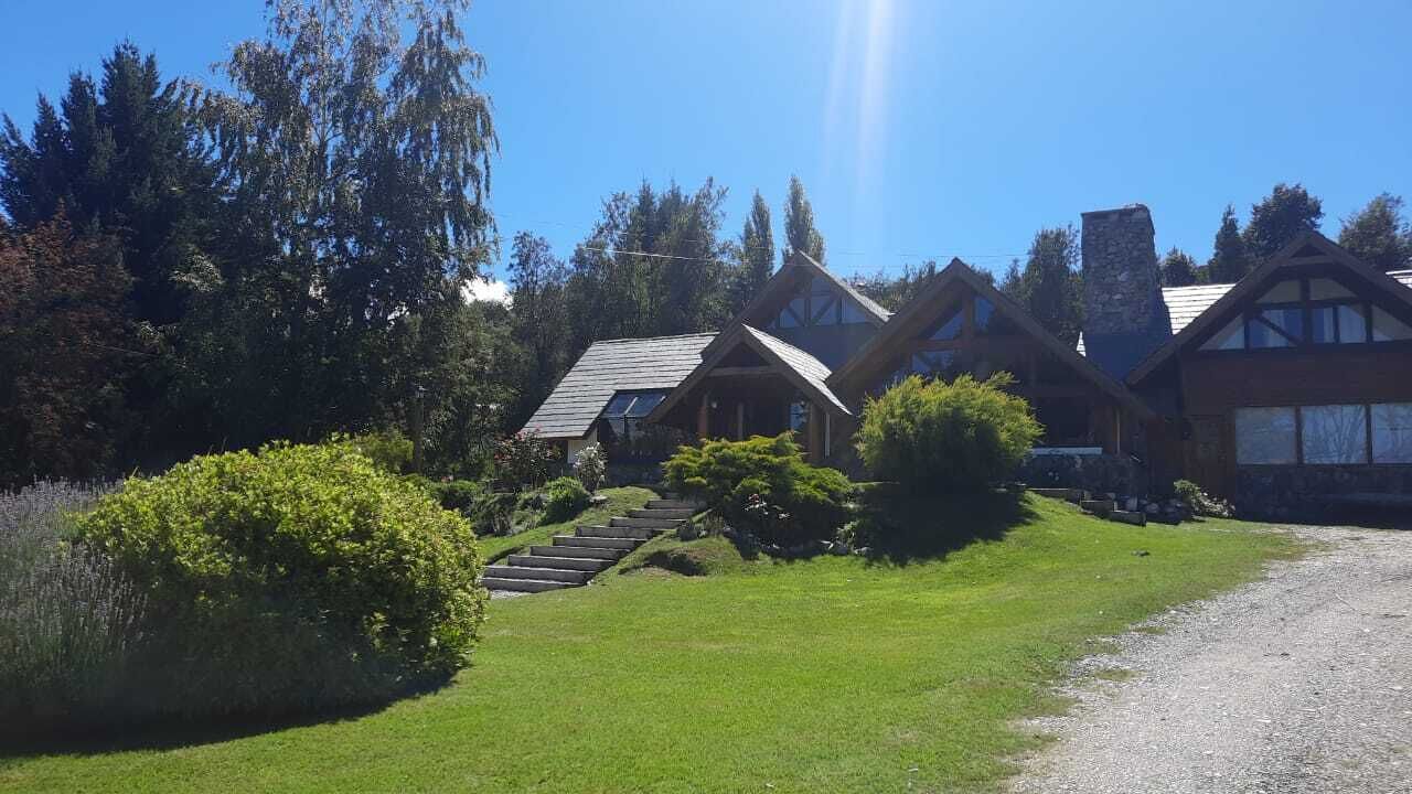 A lodge with multiple wooden cabins, a gravel driveway, and a well-maintained lawn.