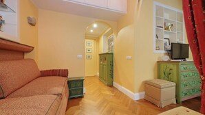 Una sala de estar acogedora con un sofá, un televisor y un mueble.