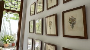 Pared con varios cuadros enmarcados de motivos botánicos.