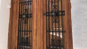Una puerta de madera con barrotes de metal y un muro con textura.