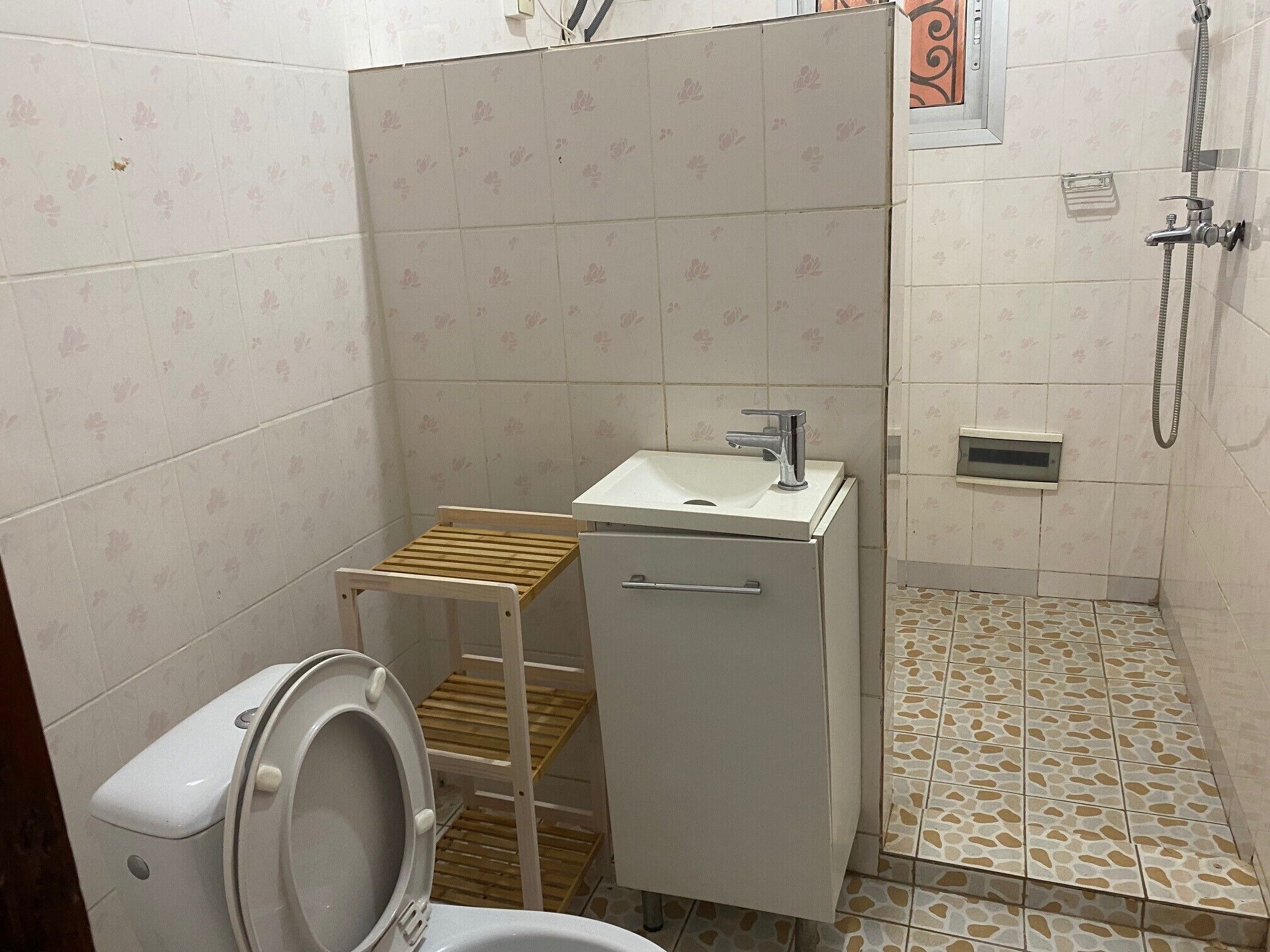 Um banheiro pequeno com vaso sanitário, pia e chuveiro.