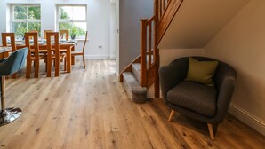 A spacious room with a dining area, a staircase, and a seating area. - Bramblewood Cottage (Barnard Castle)