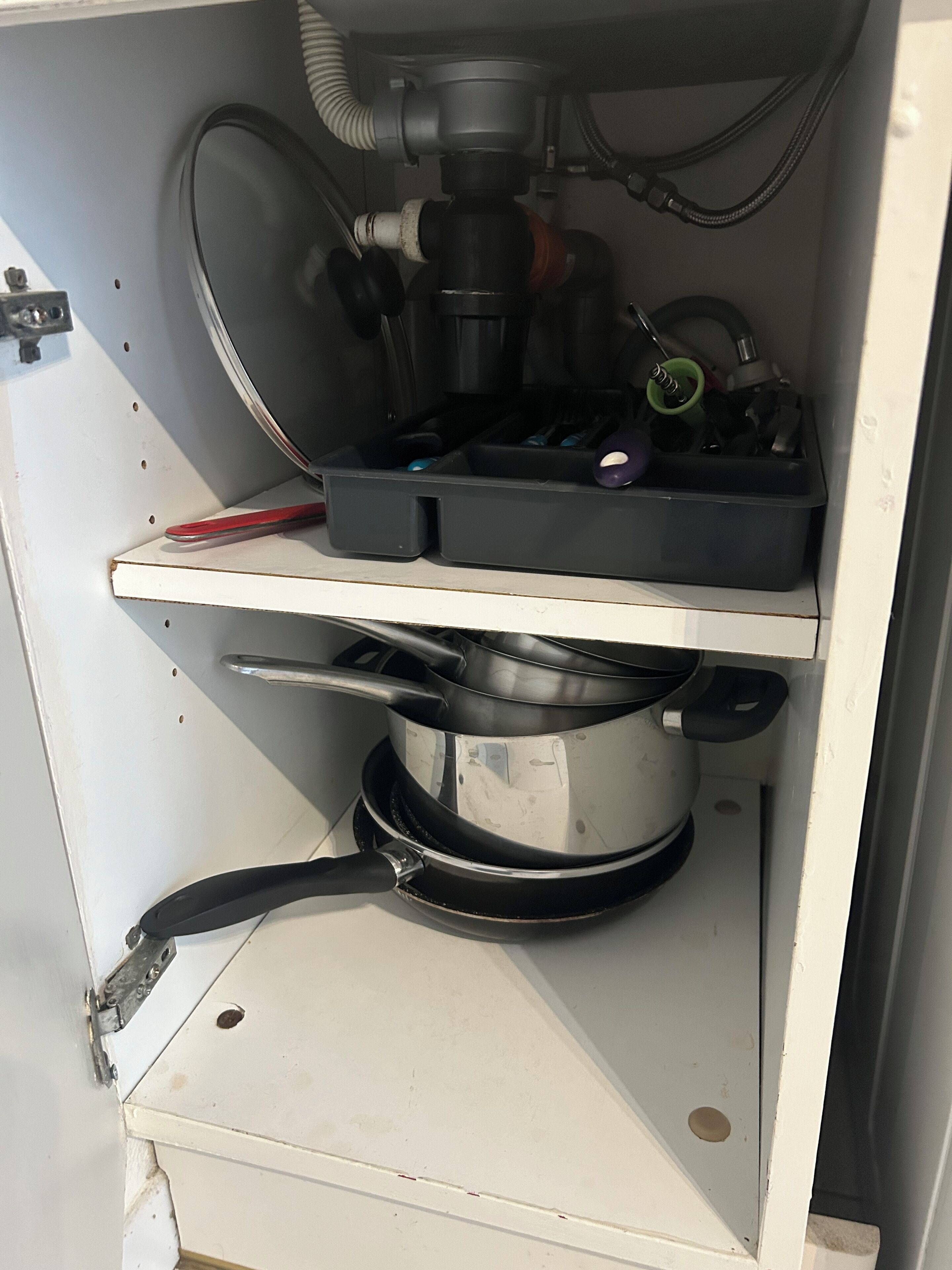 Een keuken met een fornuis, een spoelbak en een aanrecht met verschillende keukenbenodigdheden.