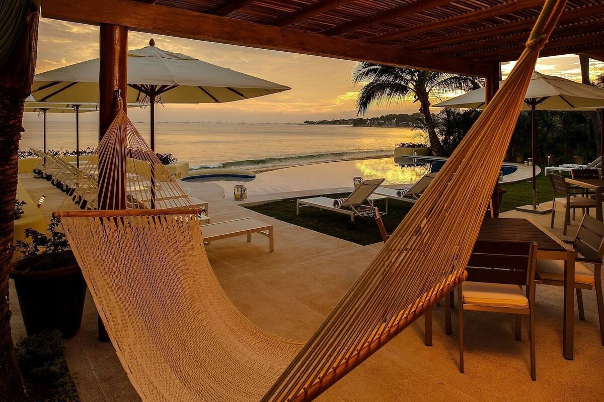 Un hamac, des chaises longues et des parasols, le tout avec vue sur la plage.