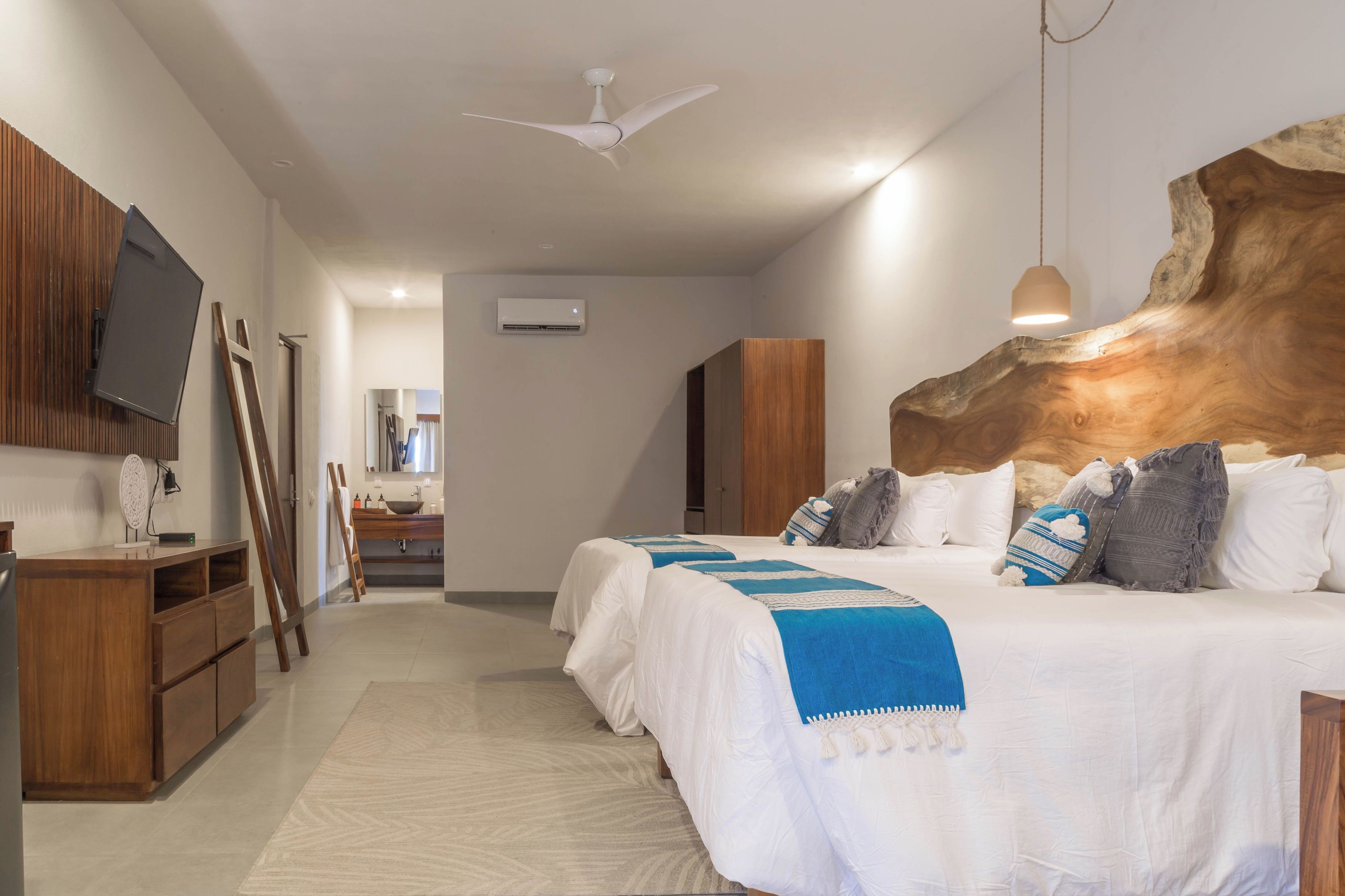 Un dormitorio moderno con una cama grande, cabecera de madera y ventilador de techo.