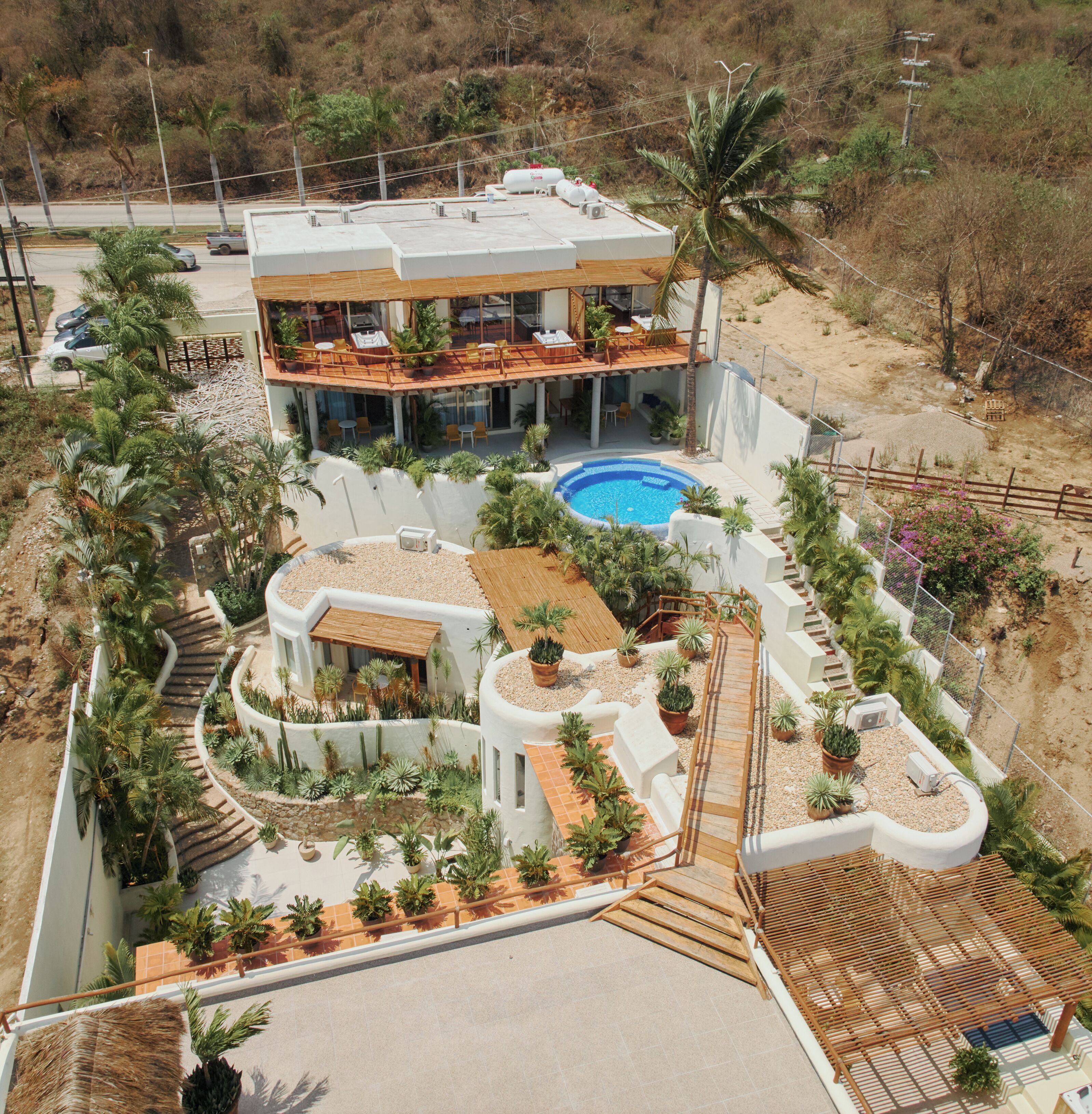 Uma casa moderna com piscina, várias áreas externas e paisagismo exuberante.