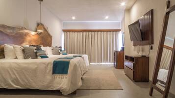 Un dormitorio moderno con una cama grande, cabecera de madera, televisor y un escritorio con silla.