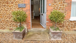 A stone cottage entrance with a sign reading "Troon Cottage". - Troon Cottage (Hunstanton)