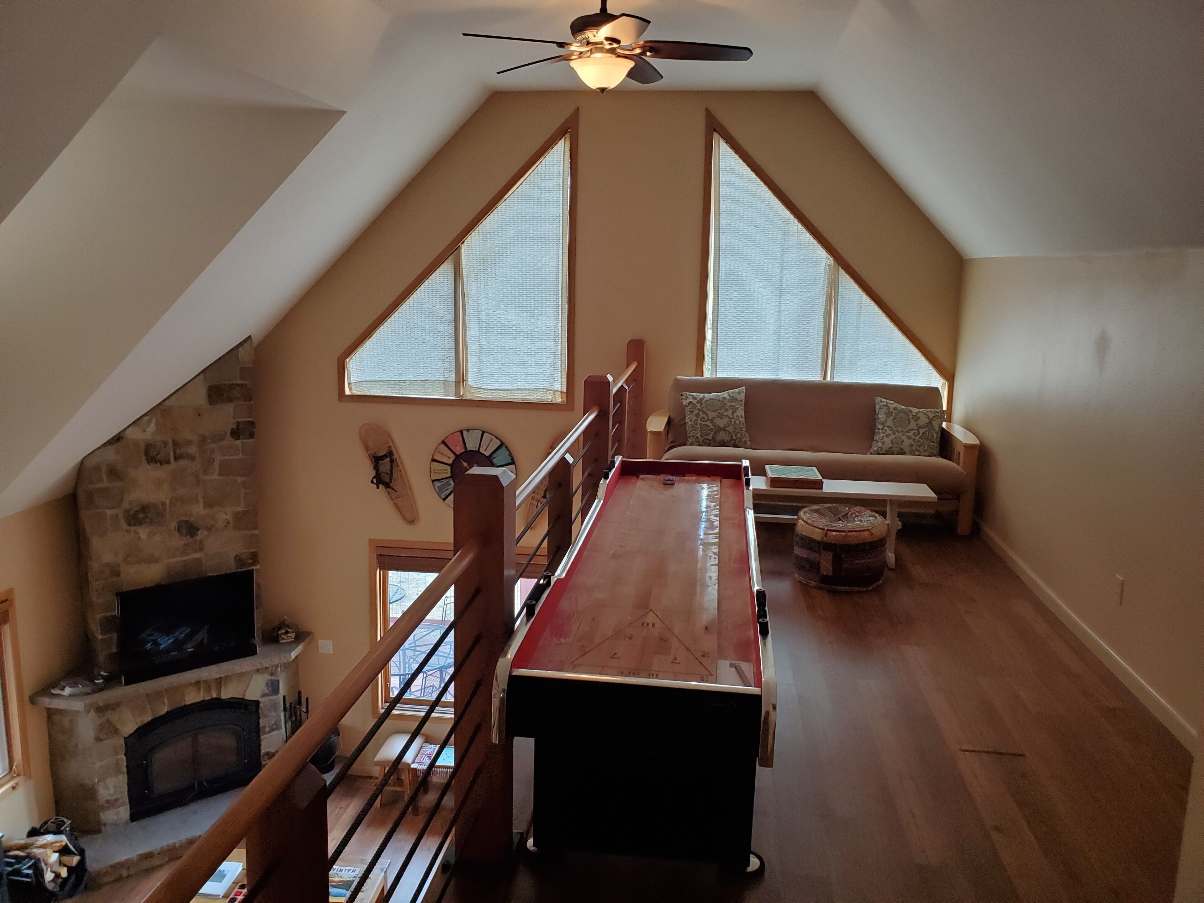 Une pièce de style loft avec une table en bois, un canapé, une cheminée et de grandes fenêtres.