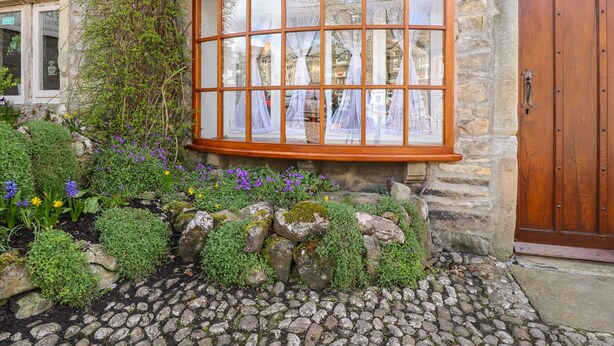 A stone building with a large bay window, a wooden door, and a sign for 'The Blestones Café'. - 2 The Square (Skipton)
