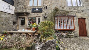 A stone building with signs for 'Bluebell Home & Gifts' and 'Cobblestones Cafe'. - 2 The Square (Skipton)