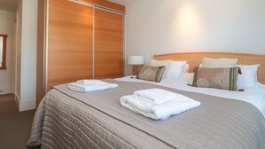 A hotel room with a large bed, a wardrobe, and a bedside table with a lamp. - 33 Dart Marina (Dartmouth)
