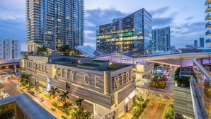 A modern urban hotel with a rooftop garden, multiple floors, and a prominent glass facade. - Suite 212 located in SLS Lux Brickell by City Escapes (Miami)