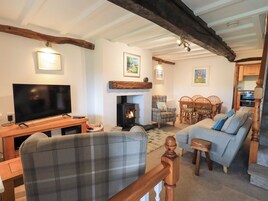 Un salón acogedor con chimenea, televisor y comedor con muebles de madera.