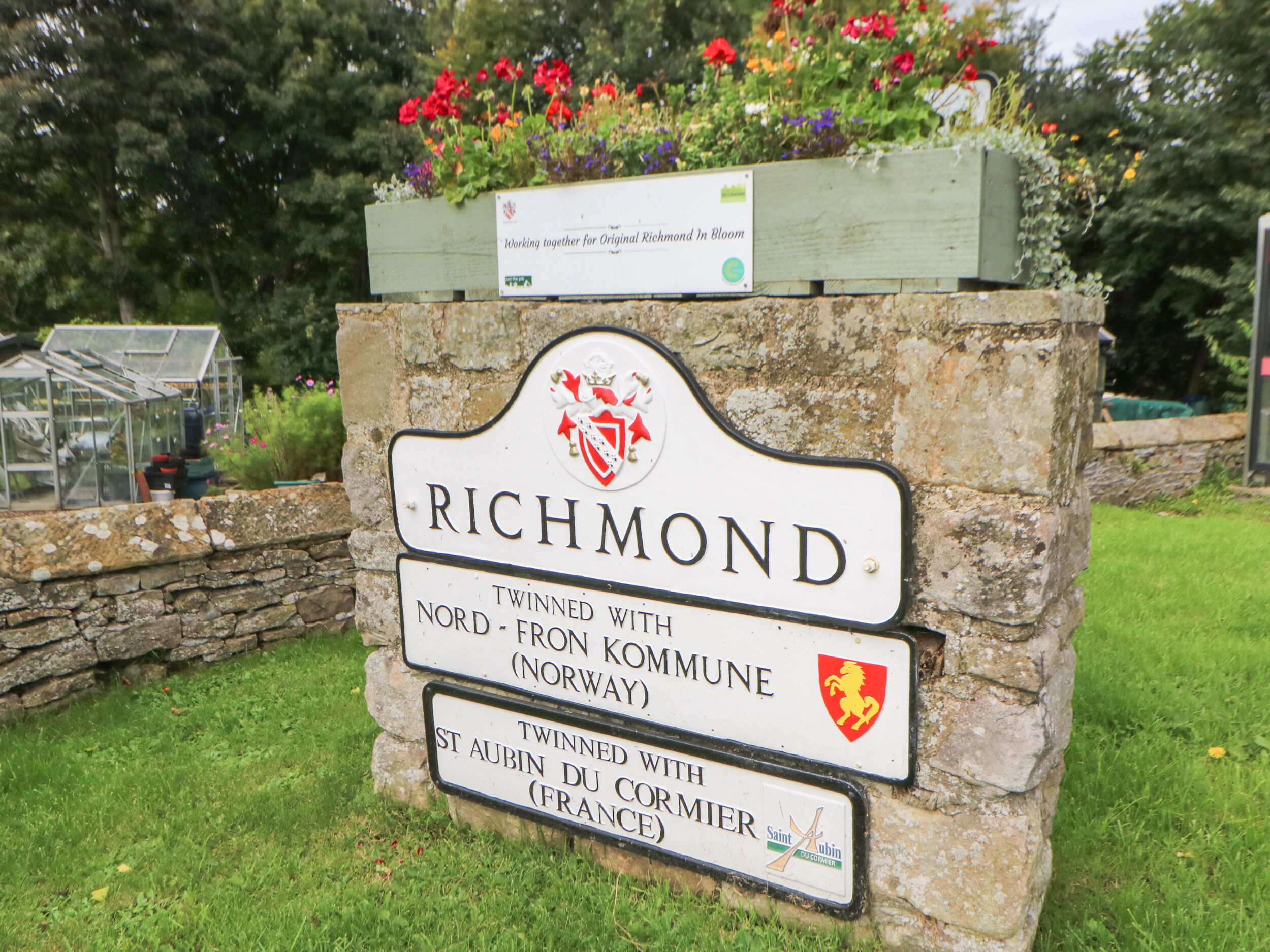 Un senyal de pedra amb el nom 'Richmond' que indica el seu vincle amb Nord-Fron Kommune (Noruega) i St Aubin du Cormier (França).