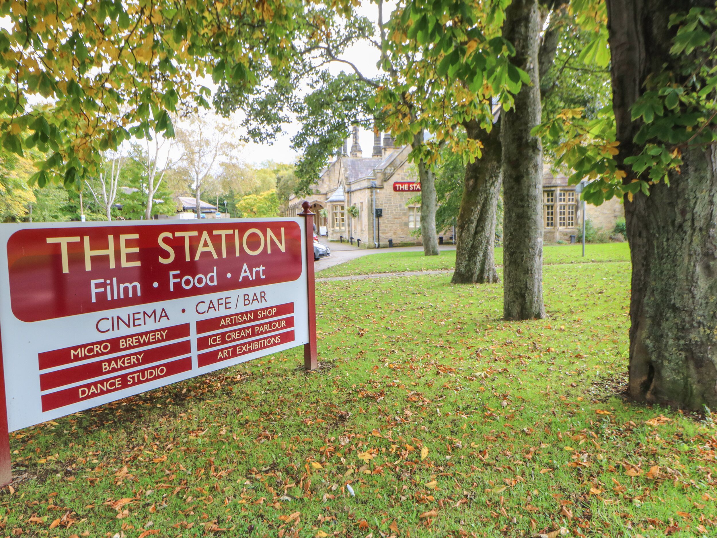 Un letrero para 'The Station' que enumera servicios como cine, cafetería y microcervecería.