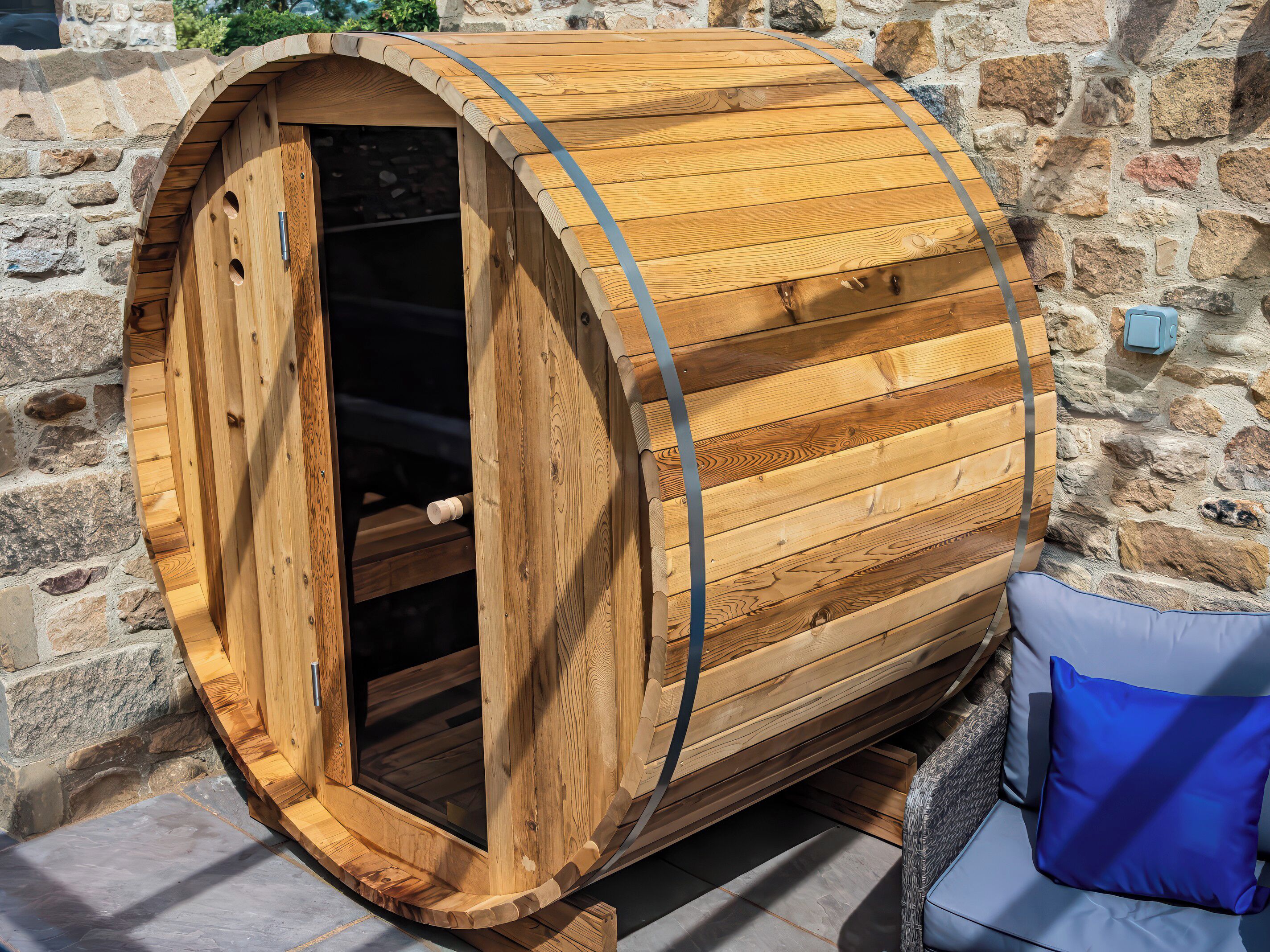 Una sauna in legno con pareti in pietra, un cuscino blu e un caminetto in pietra.