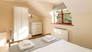 Una camera da letto con un letto, un termosifone, un armadio, una finestra vista e una lampada a soffitto.