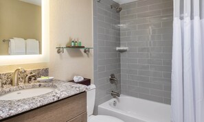 A bathroom with a marble sink, a toilet, a bathtub, and a shower with grey tiles. - 4th of July '23! Peaceful Beachfront, balcony, easy access to the beach. ENJOY (North Myrtle Beach)