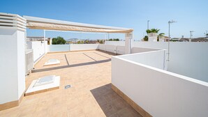 Eine Dachterrasse mit einer Pergola, einem Pool und Blick auf die Stadt.