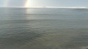 Mar tranquil amb un arc de l'iris que l'abasta.