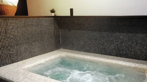 A hot tub with a tiled interior and a black and white mosaic wall. - Las Jaras Aguas Termales (Tamazula de Gordiano)
