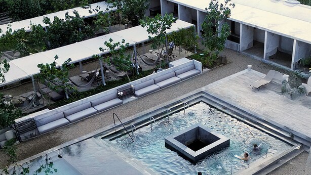 A rooftop pool with a rectangular shape, surrounded by a low wall and a seating area with benches. - Las Jaras Aguas Termales (Tamazula de Gordiano)