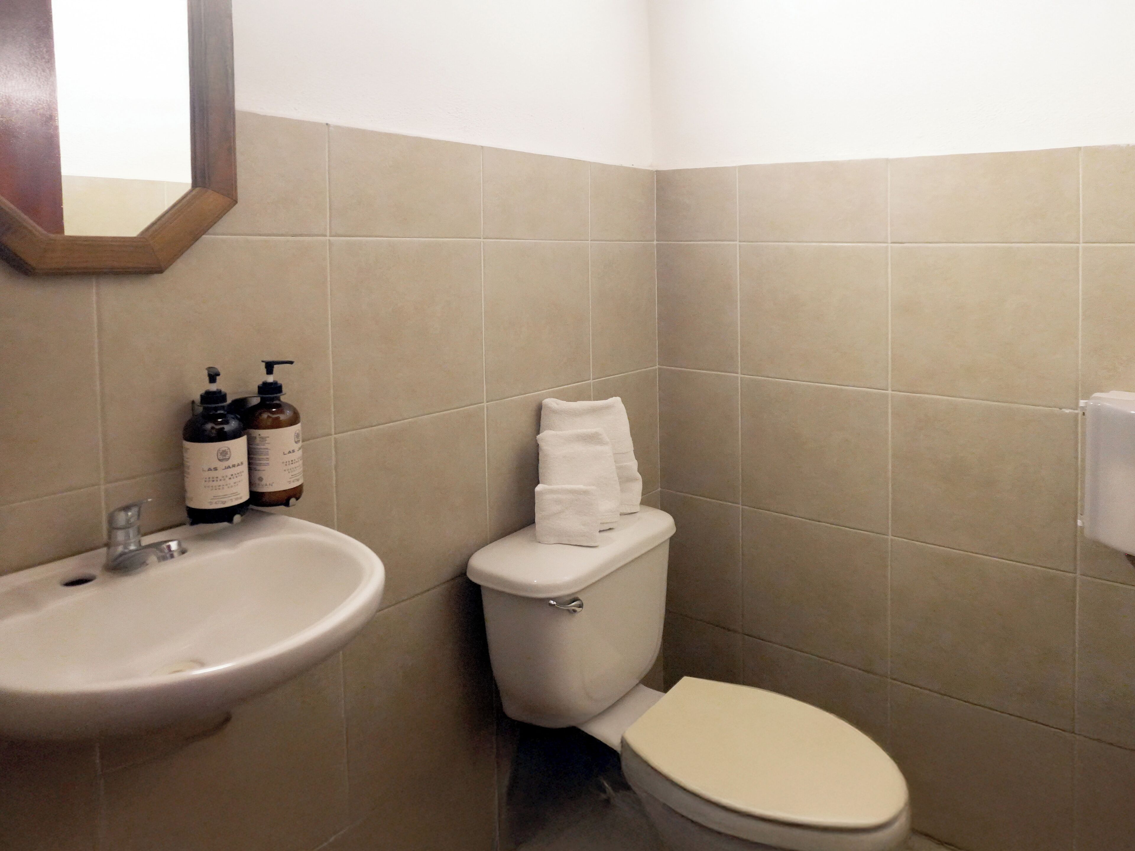 Et badeværelse med håndvask, toilet og sæbe.