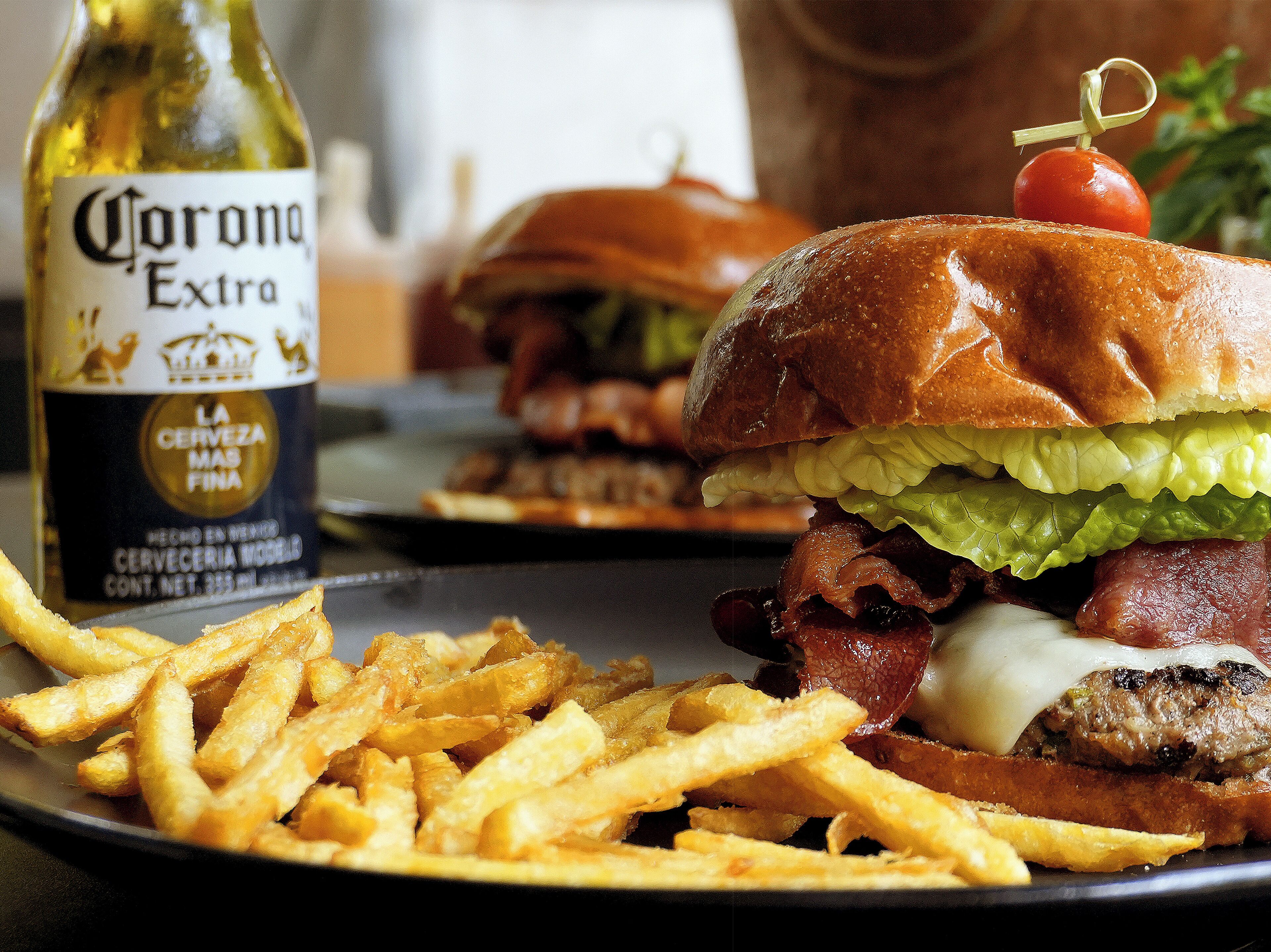 Un repas composé d’un hamburger, de frites et d’une bouteille de bière Corona Extra.